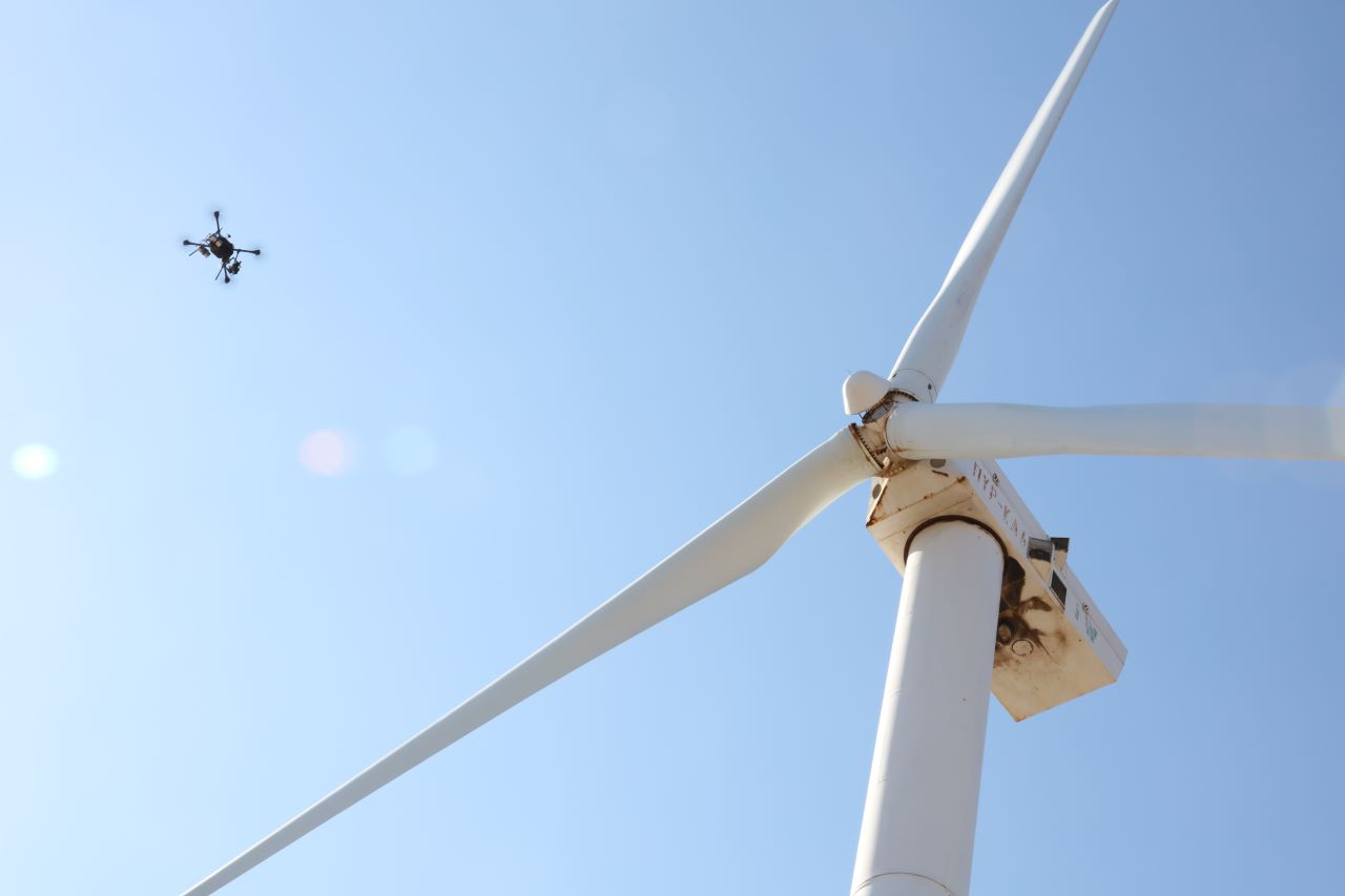 This is a photo of one of our drones inspecting a wind turbine.