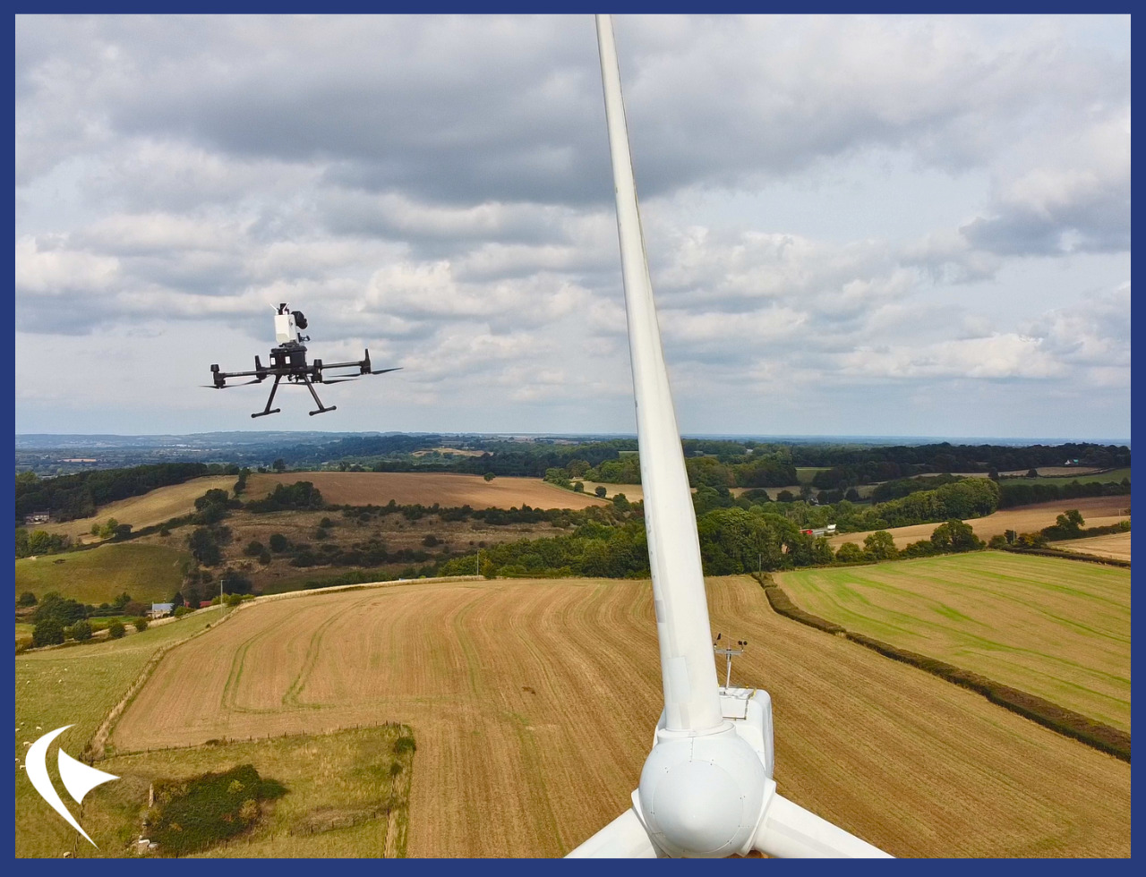 Perceptual Robotics drone and wind turbine with fields in the distance. 