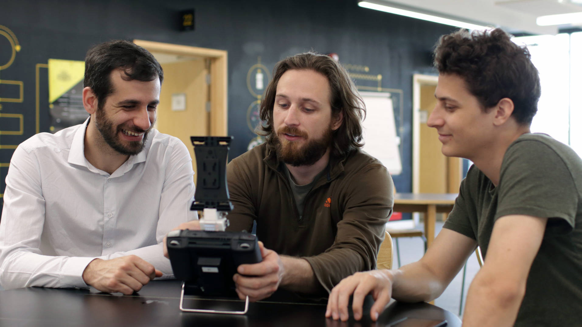 Image shows the three co-founders - Kostas, Kevin & Dimitris holding the controller for the Dhalion system