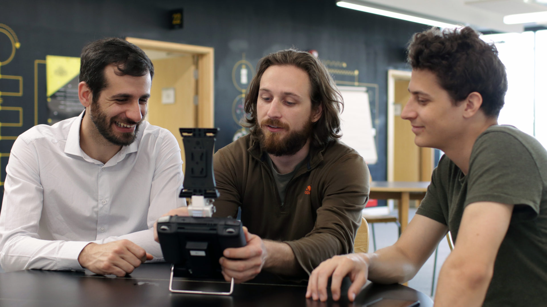 Image shows the three co-founders - Kostas, Kevin & Dimitris holding the controller for the Dhalion system
